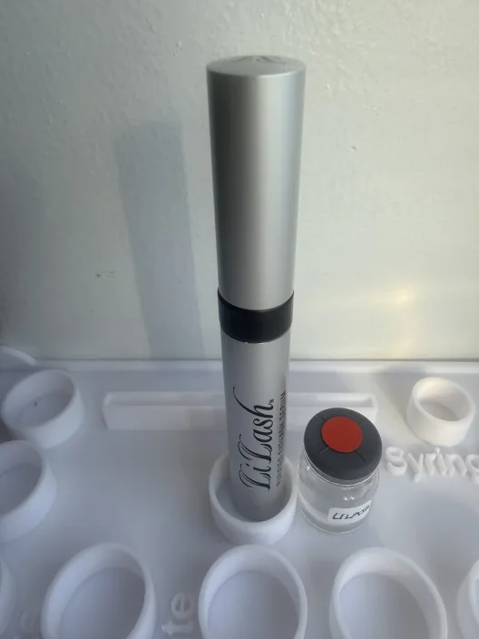 LiLash serum tube beside a small vial labeled LiLash in a white holder