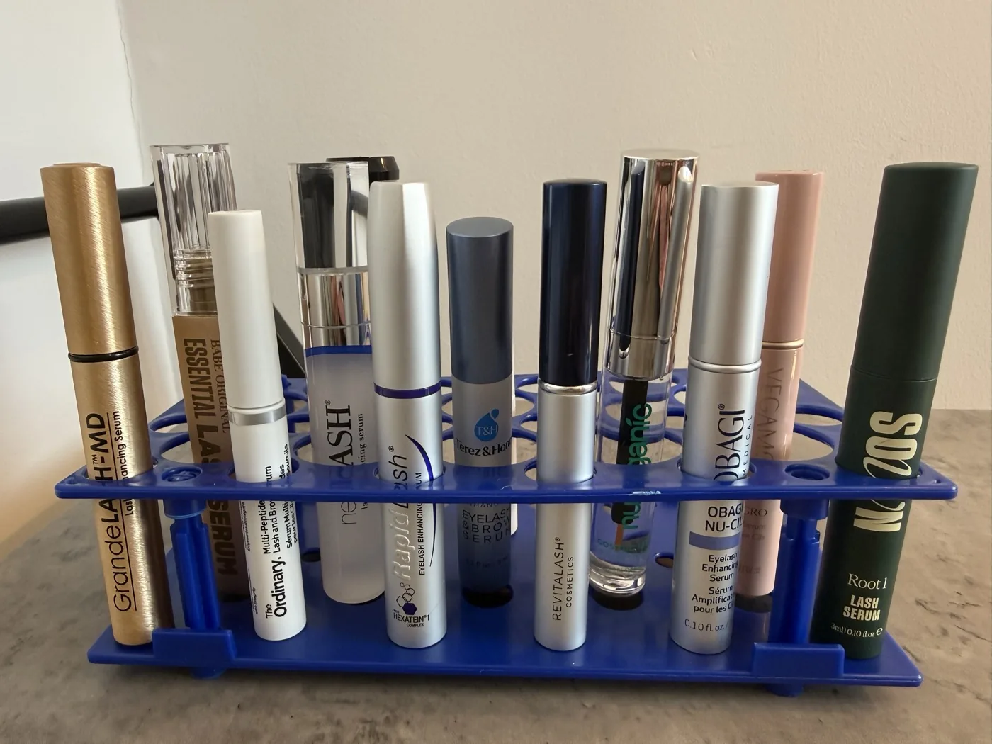 Thirteen lash serum tubes aligned in The Lash List comparison rack